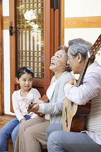 祖孙三人坐在门口弹吉他图片