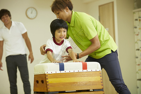 教学指导男孩跳箱的老师图片