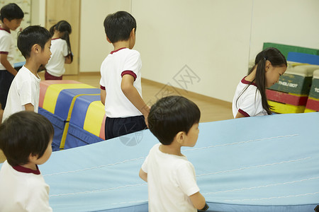 幼儿园的孩子女人个人指导孩子们准备锻炼室垫运动图片