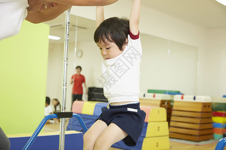 吊在单杠上练习的儿童图片