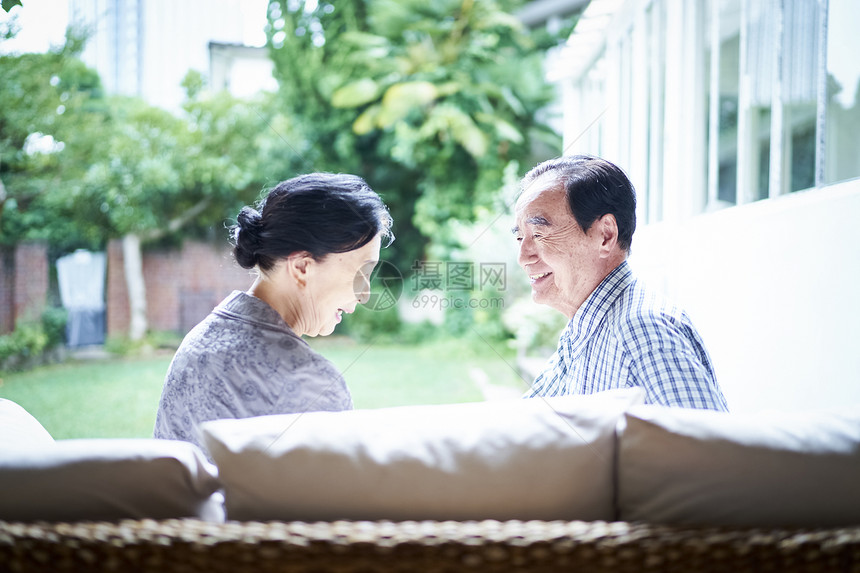 坐在沙发上休息聊天的老夫妇图片