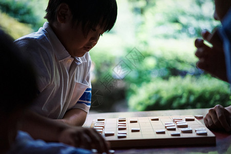 看着棋盘下棋的小男孩图片