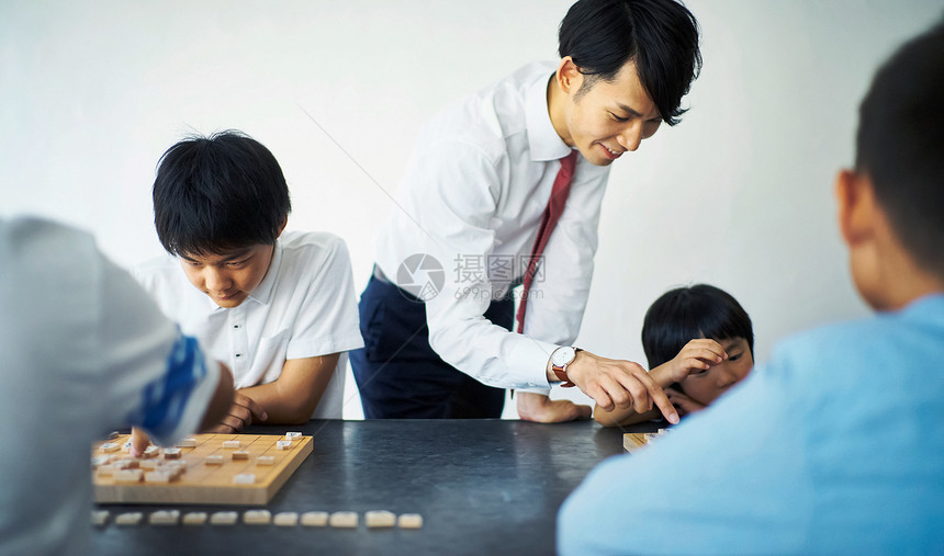 室内指导孩子们下棋的教师图片