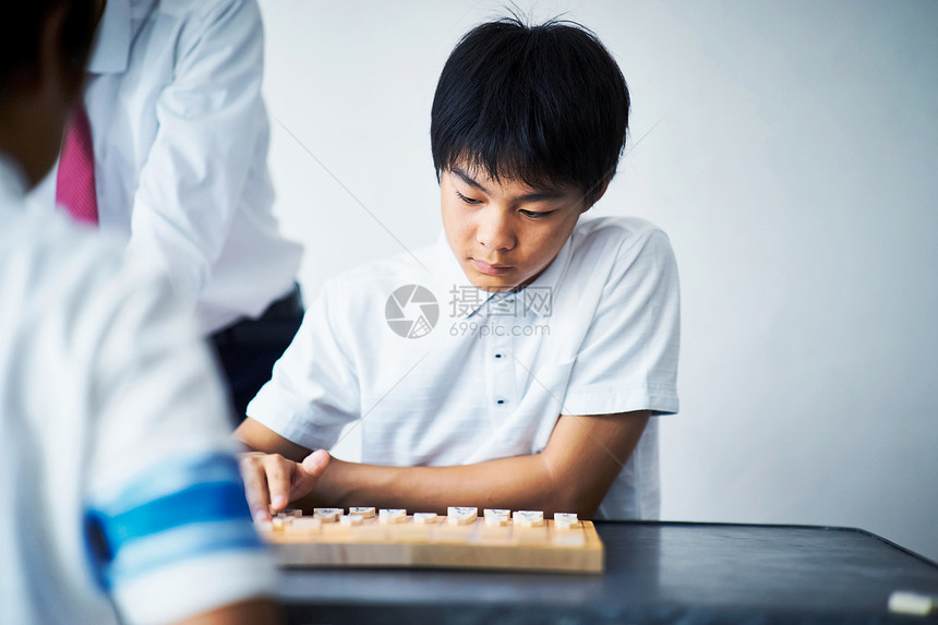 看着棋盘下棋的男孩图片