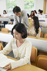 老师指正学生作业年轻女子高清图片素材