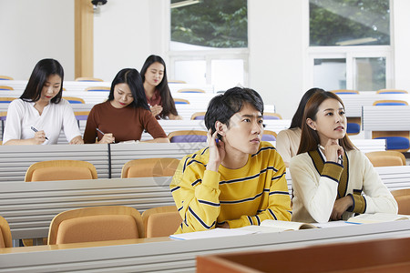大学课堂上的男女大学生书桌高清图片素材