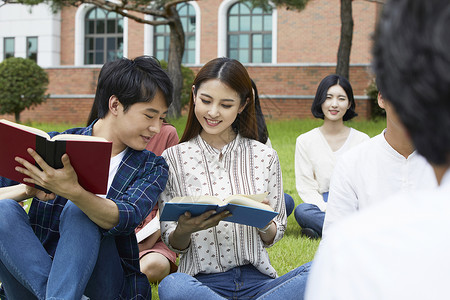 草坪上看书的大学生图片