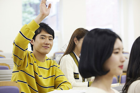 举手提问的男大学生图片