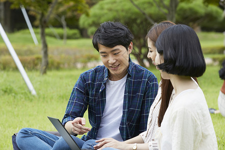 看着笔记本电脑讨论学习的大学生图片