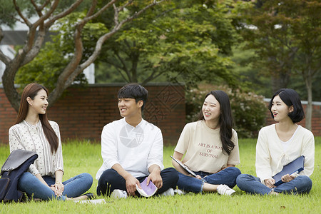 草坪上聊天休息的青年大学生图片