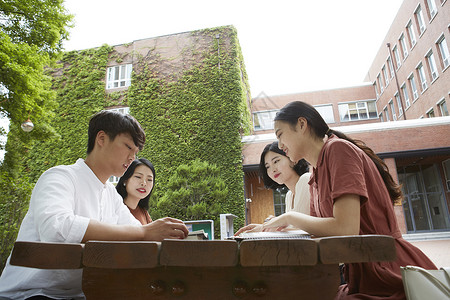 校园野餐桌上的的青年大学生阅读高清图片素材