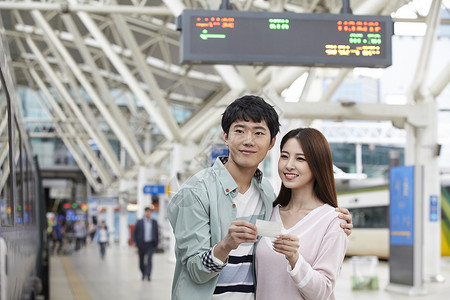 火车站拿着车票的年轻情侣图片