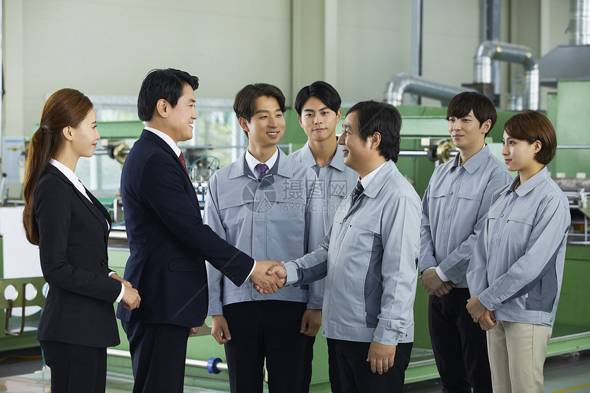 商务男士和工厂技术握手合作图片