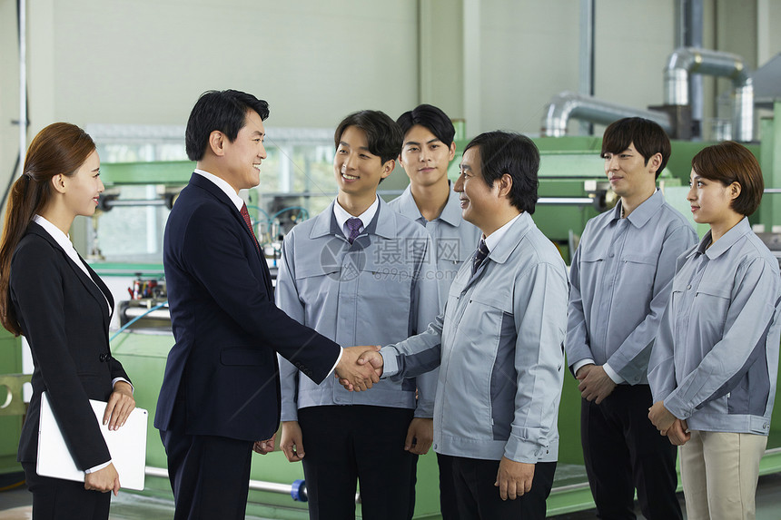 商务男士和工厂技术握手合作图片