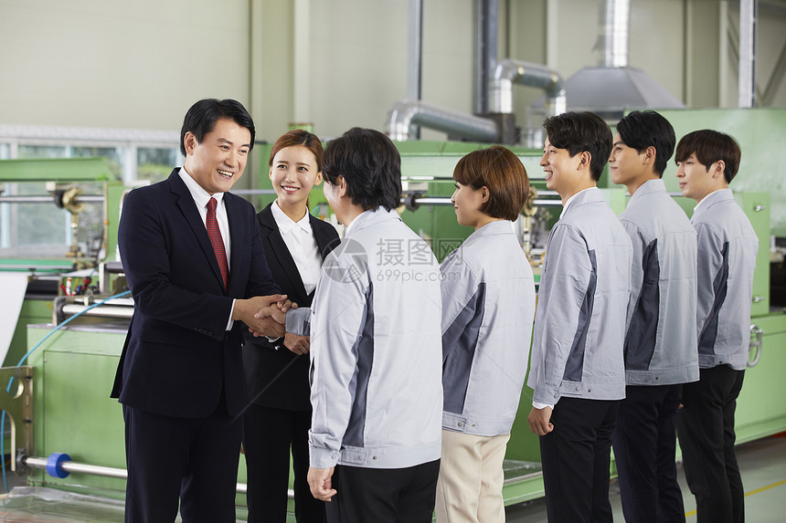 商务男士领导和工厂技术工人握手合作图片