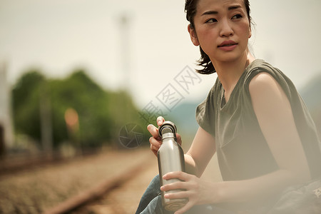 在废弃铁道上喝水的旅行者图片