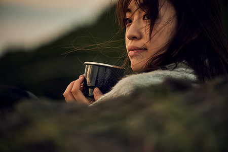 户外手拿杯子喝咖啡的女性放松的高清图片素材