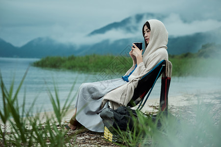 有趣室外二十多岁女背包客湖边茶时间喝高清图片素材