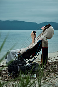 愉快放松的东北地区女背包客湖边茶时间欢快高清图片素材