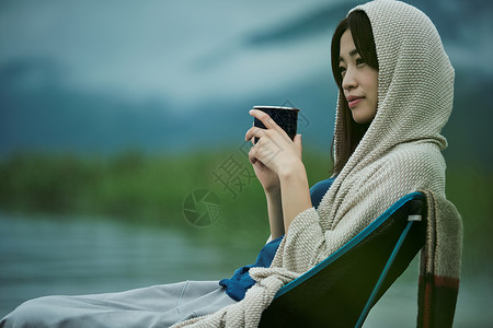 露营椅子欢快女背包客湖边茶时间饮料高清图片素材