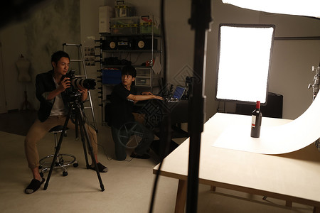 摄影师在工作室拍摄静物酒高清图片素材