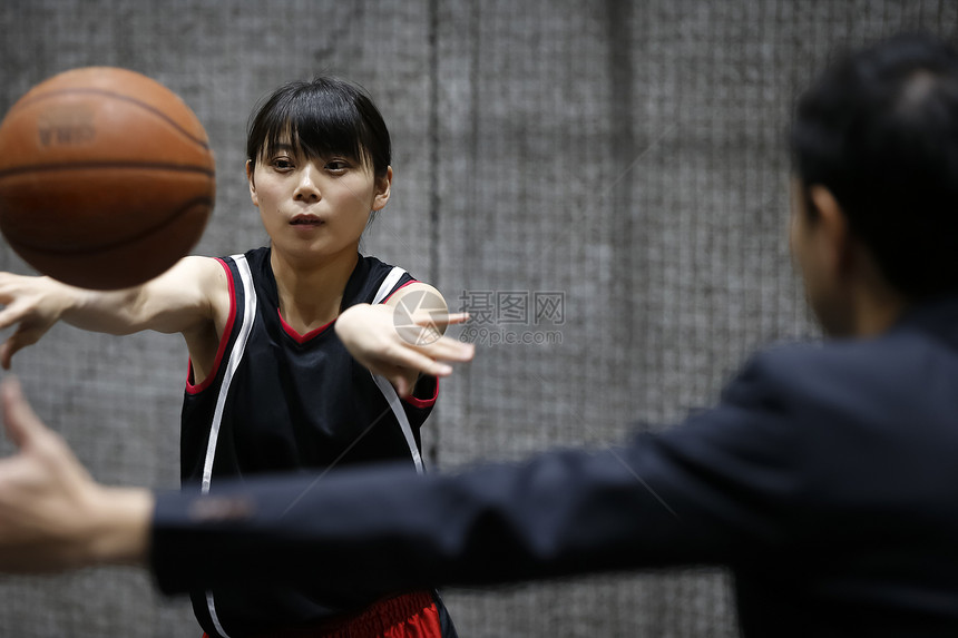 年轻女子在室内篮球场打球图片