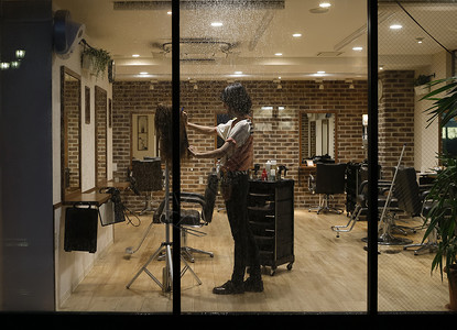 美发师的助理练习剪头发日本人高清图片素材