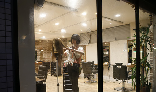 美发师的助理练习剪头发理发师高清图片素材