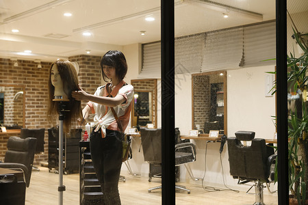 美发师的助理练习剪头发割高清图片素材