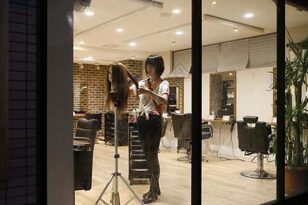 深夜理发店内练习的美发师助理发廊高清图片素材
