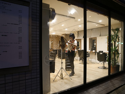夜晚理发店内练习的美发师助理日本人高清图片素材