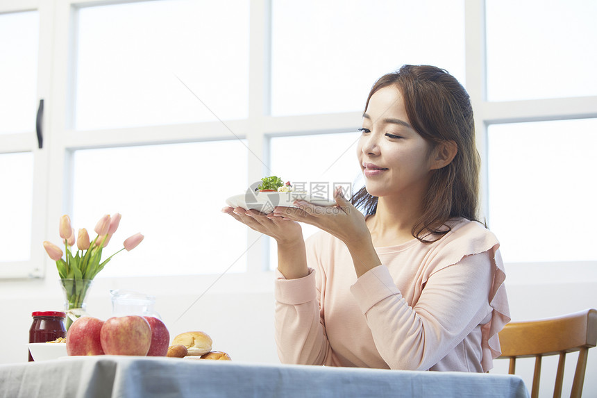 捧着沙拉微笑的女性图片