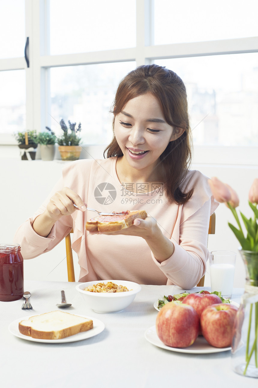 涂抹果酱微笑的年轻女性图片