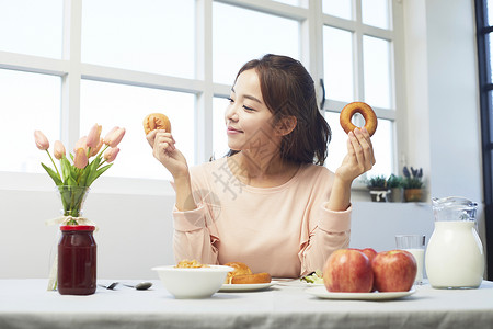 早午餐双手拿着面包微笑的女性图片