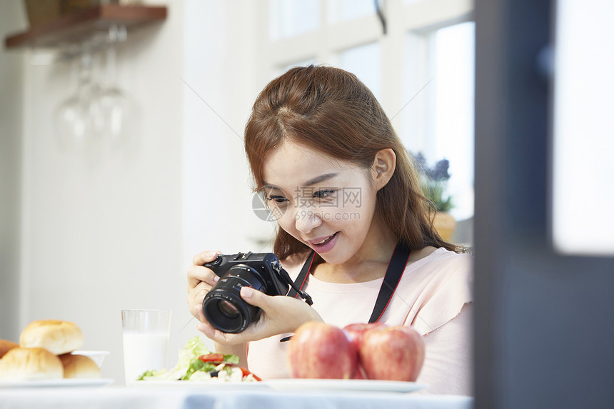 居家女性用照相机拍菜图片