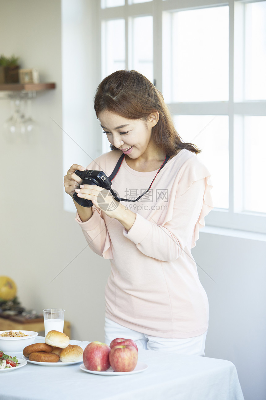 居家女性用照相机拍菜图片