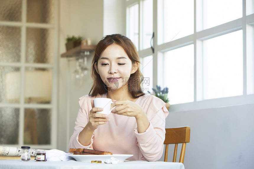 年轻女子享受早餐图片