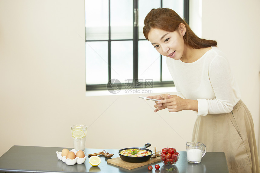 年轻女子手机拍照食物图片图片