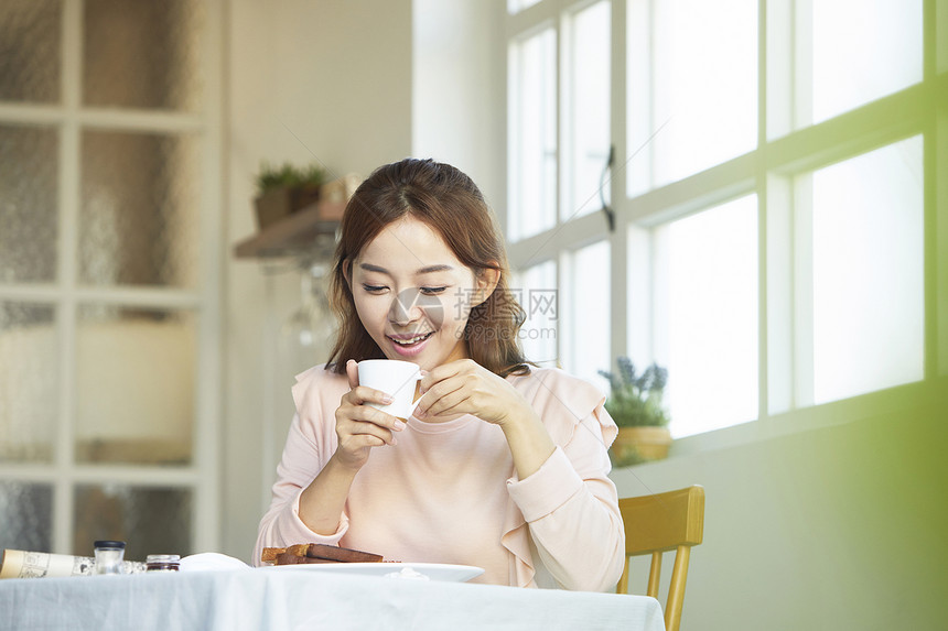 咖啡馆享用下午茶的女青年图片