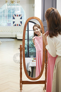 站在镜子前试裙子的女青年图片