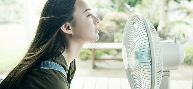 在家吹风扇的妇女图片