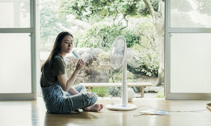 在家吹风扇吃冰棒的妇女图片