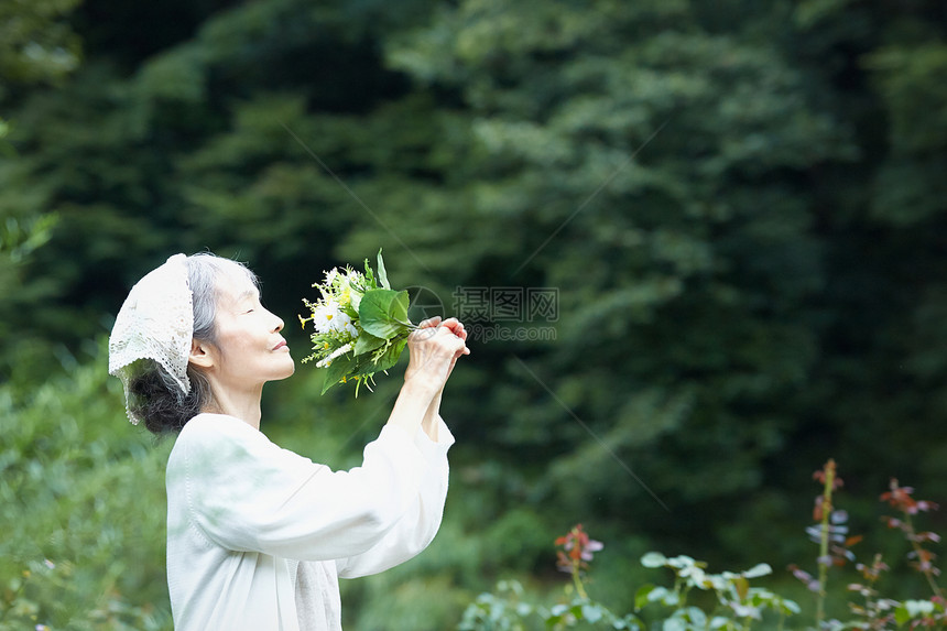 捧着花束闻的女性图片