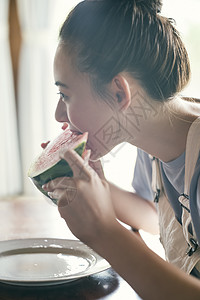 吃着西瓜开心的年轻女性背景图片
