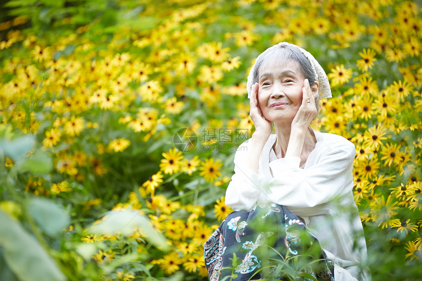 坐在花田里放松的老年人图片