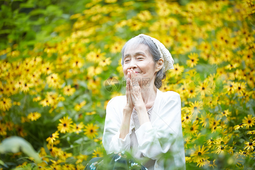 院子植物的自然放松的老年妇女图片