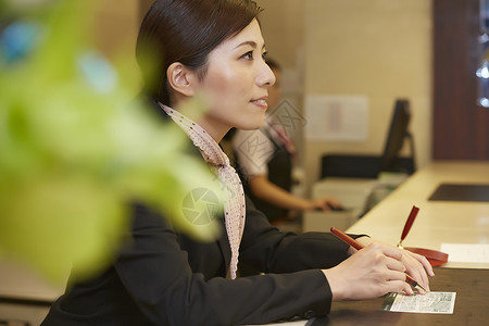 亚洲人登记服务台在酒店接待处工作的女人图片