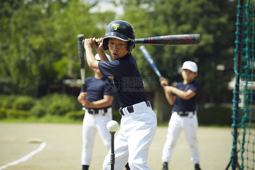 敲击头盔小学男孩棒球男孩实践的打击画象图片