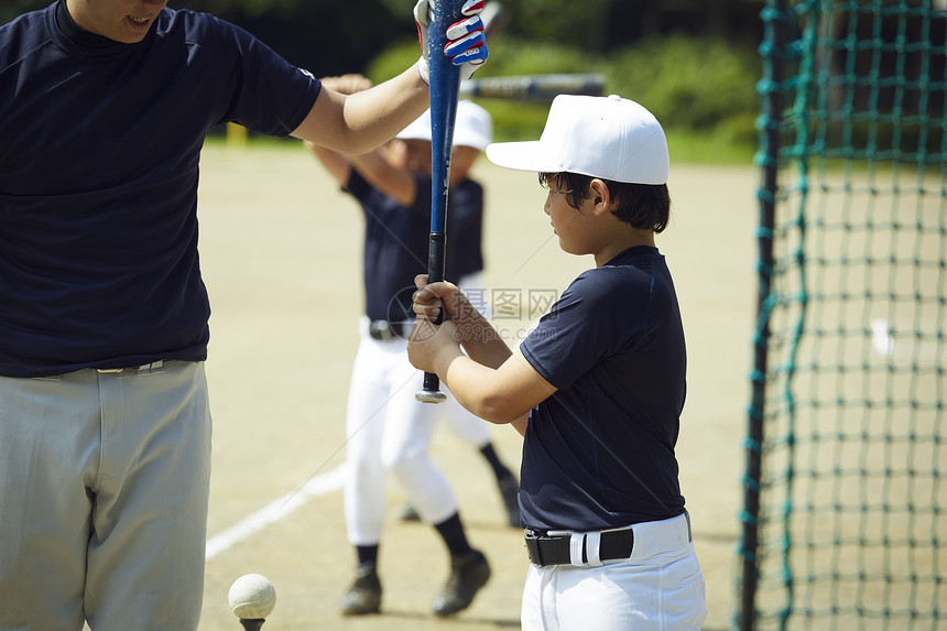 男子两个人制服男孩棒球男孩练习击球图片