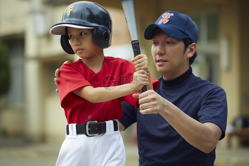 制服选手指导男孩棒球男孩练习击球图片